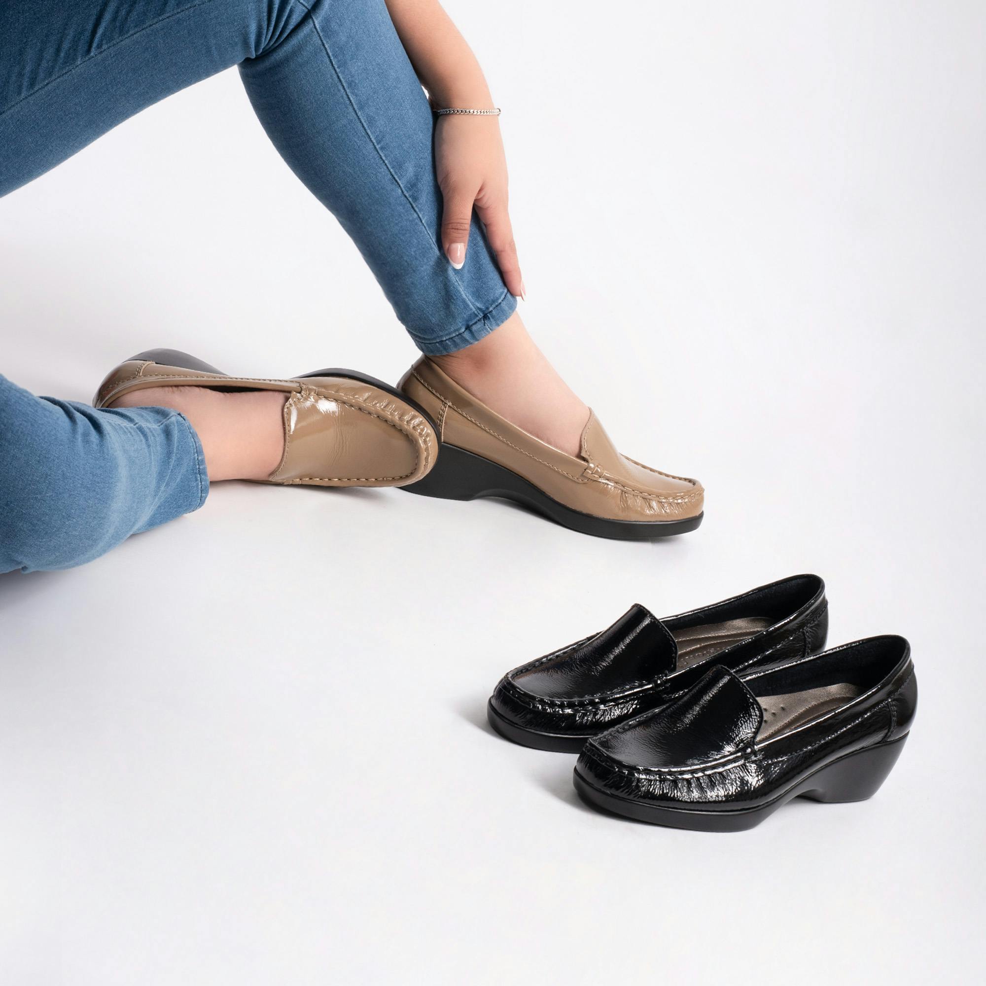 Women sitting on the floor with 2 pairs of loafers 
