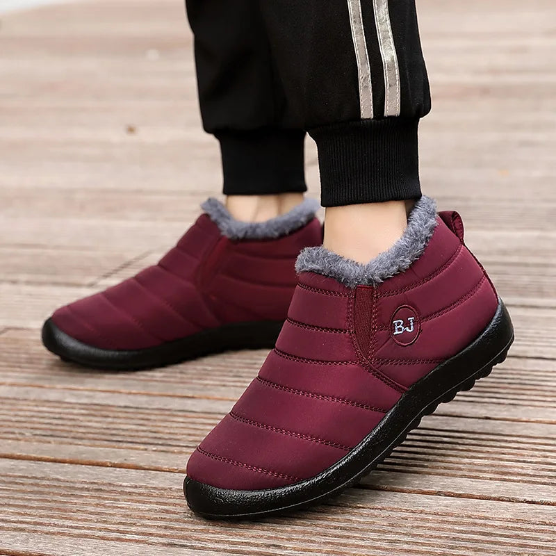 Woman wearing burgundy waterproof winter booties with pants showing versatile casual style