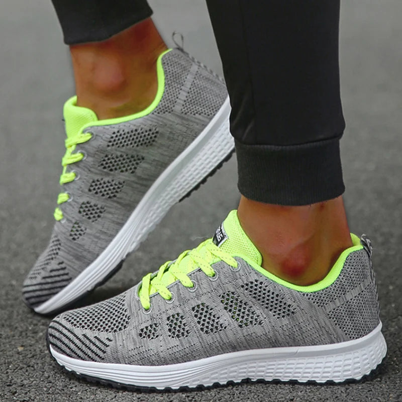 Gray athletic sneakers with neon green accents featuring breathable mesh upper for gym and running