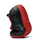 Close-up of textured red rubber non-slip sole on waterproof work shoes